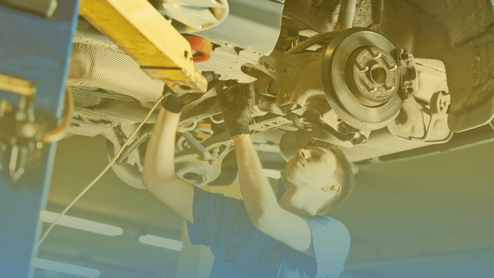 technician working on underside of vehicle 